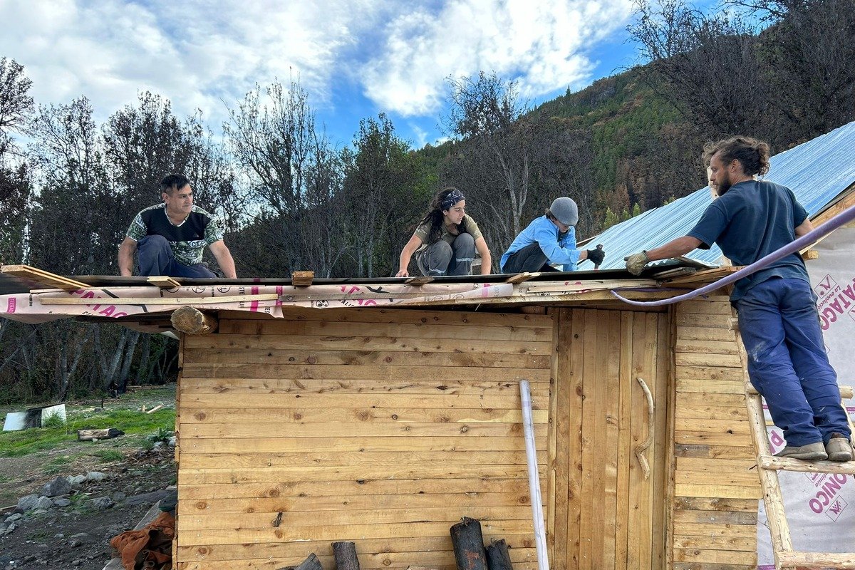 Voluntarios reconstruyendo una vivienda tras el incendio forestal de Epuyén Chubut seguro de hogar Argentina
